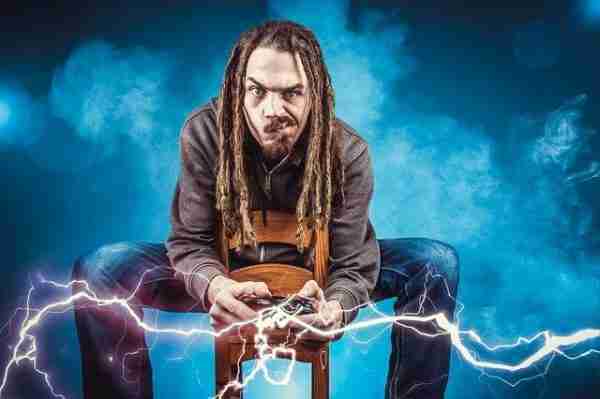 Man with dreads playing video games, electric shock from controller.