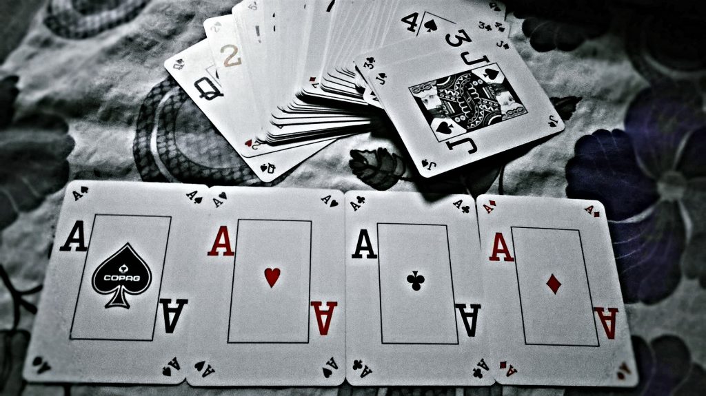 4 aces played on table, deck of cards