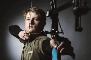 boy shooting bow, archery hobby, marksmen