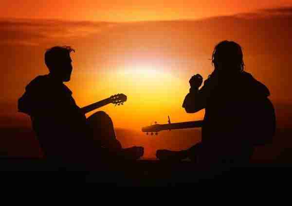 two people playing guitar in sunset, hobby