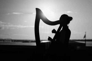 woman playing harp, black and white, string instrument