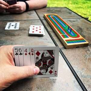 2 people playing cribbage on picnic table