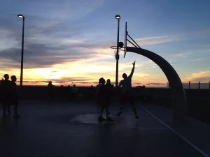 friends playing basketball. dusk, team sports