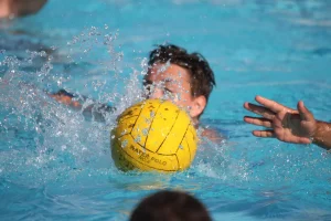 child playing water polo, ball in the water, 
