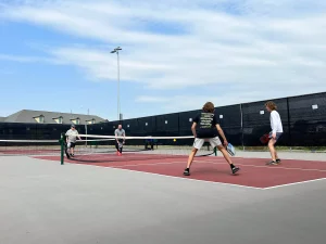 several people playing pickleball, doubles