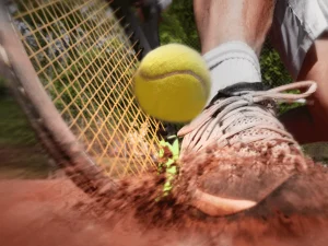 racket and ball hitting clay court, shoe
