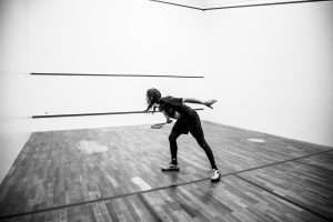 black and white squash court and player